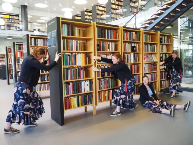 Fotomanipulation af kvinde der forsøger at flytte en reol fyldt med bøger